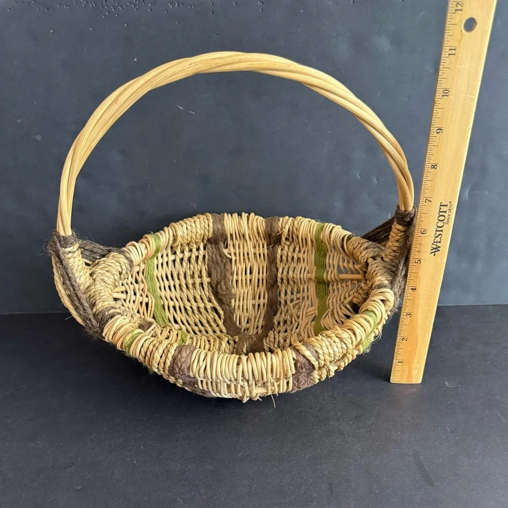 Vintage handwoven basket with brown and green yarn details and eye of God.